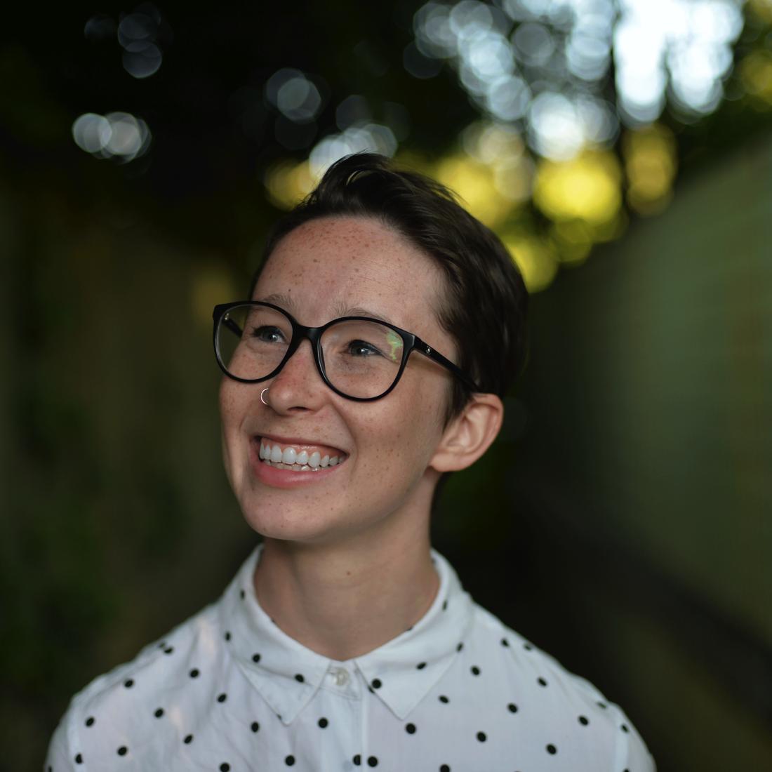 Photo of woman with short dark hair smiling and face angled upward