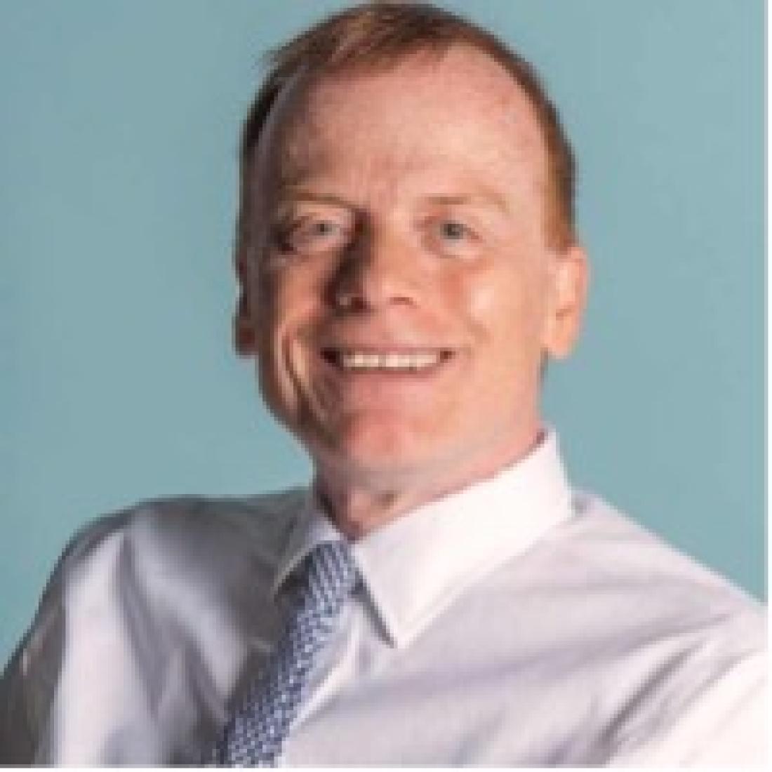 headshot of male faculty member wearing white shirt with tie and smiling