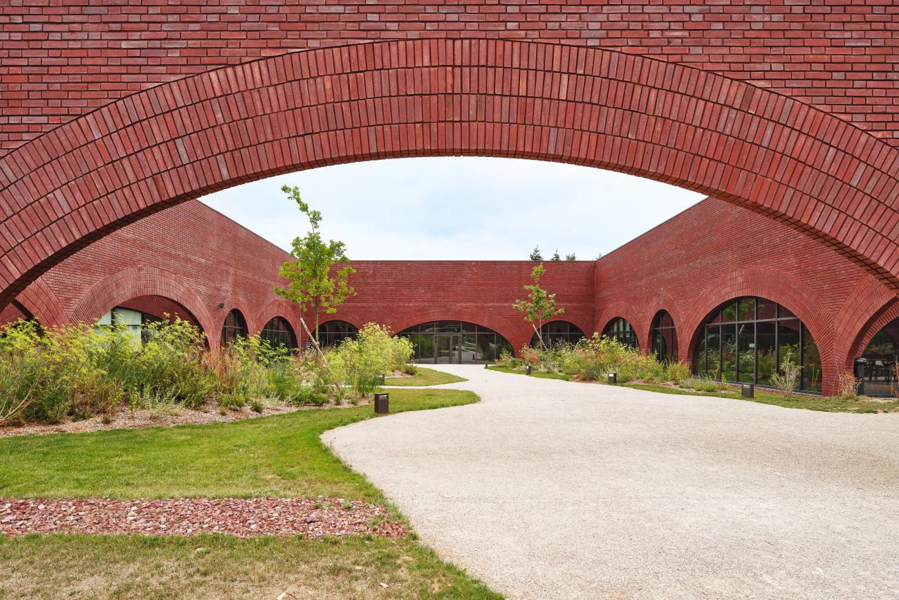 A red brick building with archways along the facade.