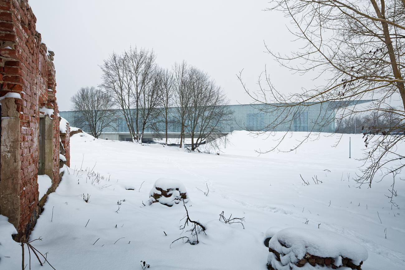 A large glass shed-like building sits in a snowy landscape.