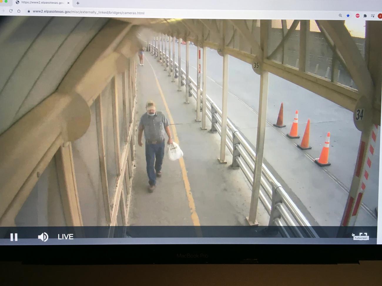 A man walks on a pedestrian path viewed from a top angle