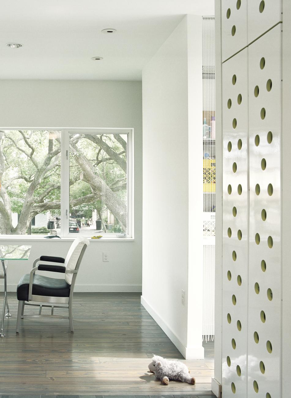 Custom brake-form perforated steel doors and concealed storage adjacent to dining area