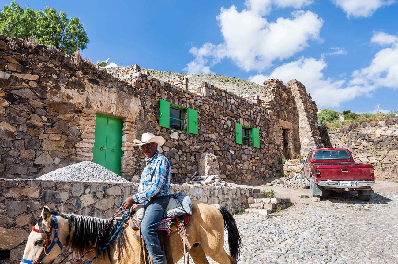 Photograph of man riding horse