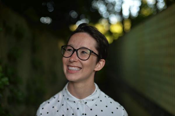 Photo of woman with short dark hair smiling and face angled upward