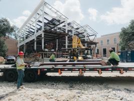 photo of steel structure during building process and workers wearing hard hats